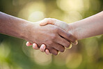 Community, handshake and support hand sign of diversity to show solidarity and trust. Welcome or greeting of hands together showing collaboration, partnership or deal agreement outdoors with bokeh