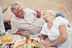 Food, beach and picnic senior couple dating or on romantic honeymoon date with fruit, snack and drink. Happy, love and romance woman and man or elderly people eating and feed together for anniversary