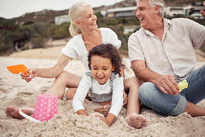 Buy stock photo Family, beach and a girl and her grandparents playing in the sand outside during summer. Kids, love and vacation with a man and woman and granddaughter laughing and bonding outdoor