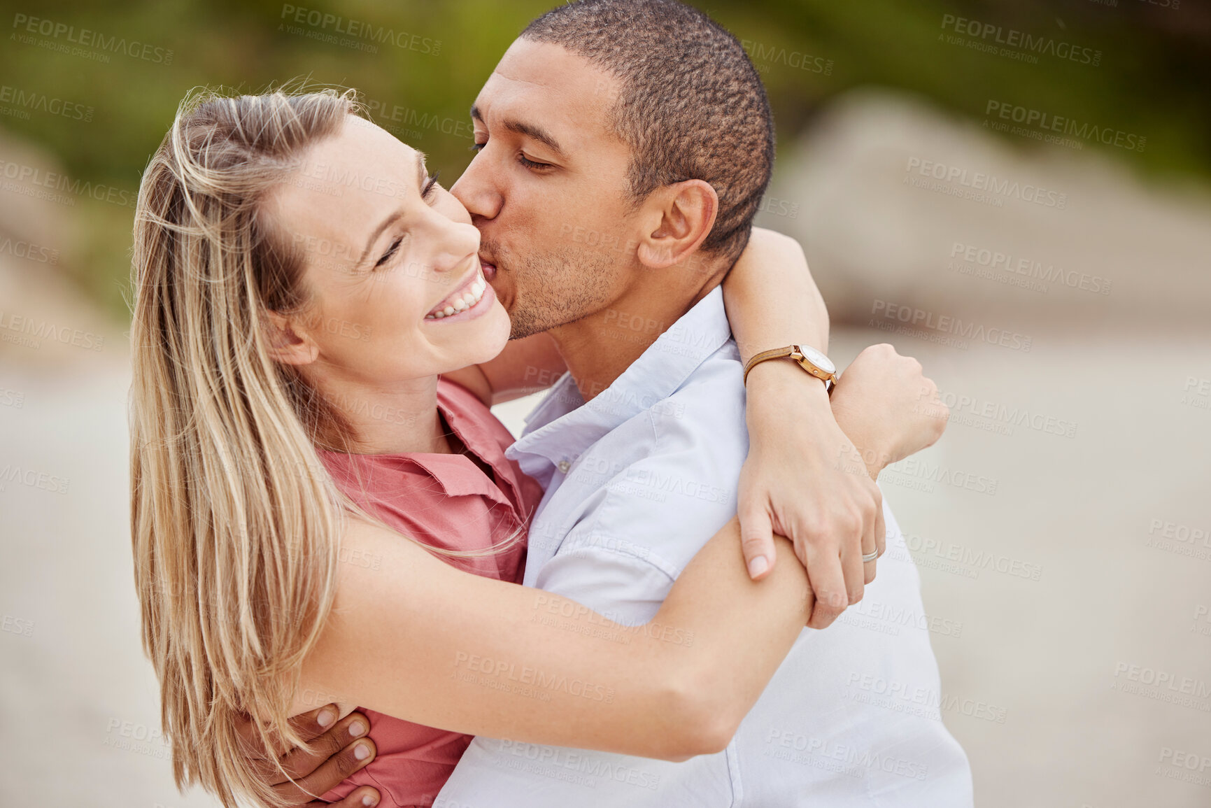 Buy stock photo Smile, love and happy couple kiss on the cheek on honeymoon vacation outdoors to celebrate their marriage. Happiness, interracial and smiling woman enjoys traveling on romantic trip with her partner