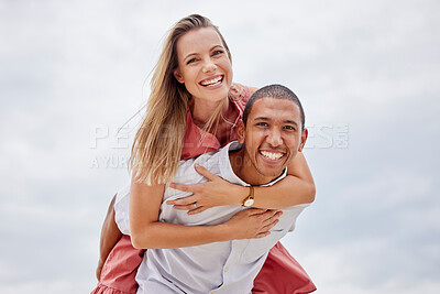 Buy stock photo Love, couple and diversity with a happy couple outside on a cloudy day with the sky in the background. Portrait of a young man carrying a woman on his back for a piggyback ride with a smile outdoors