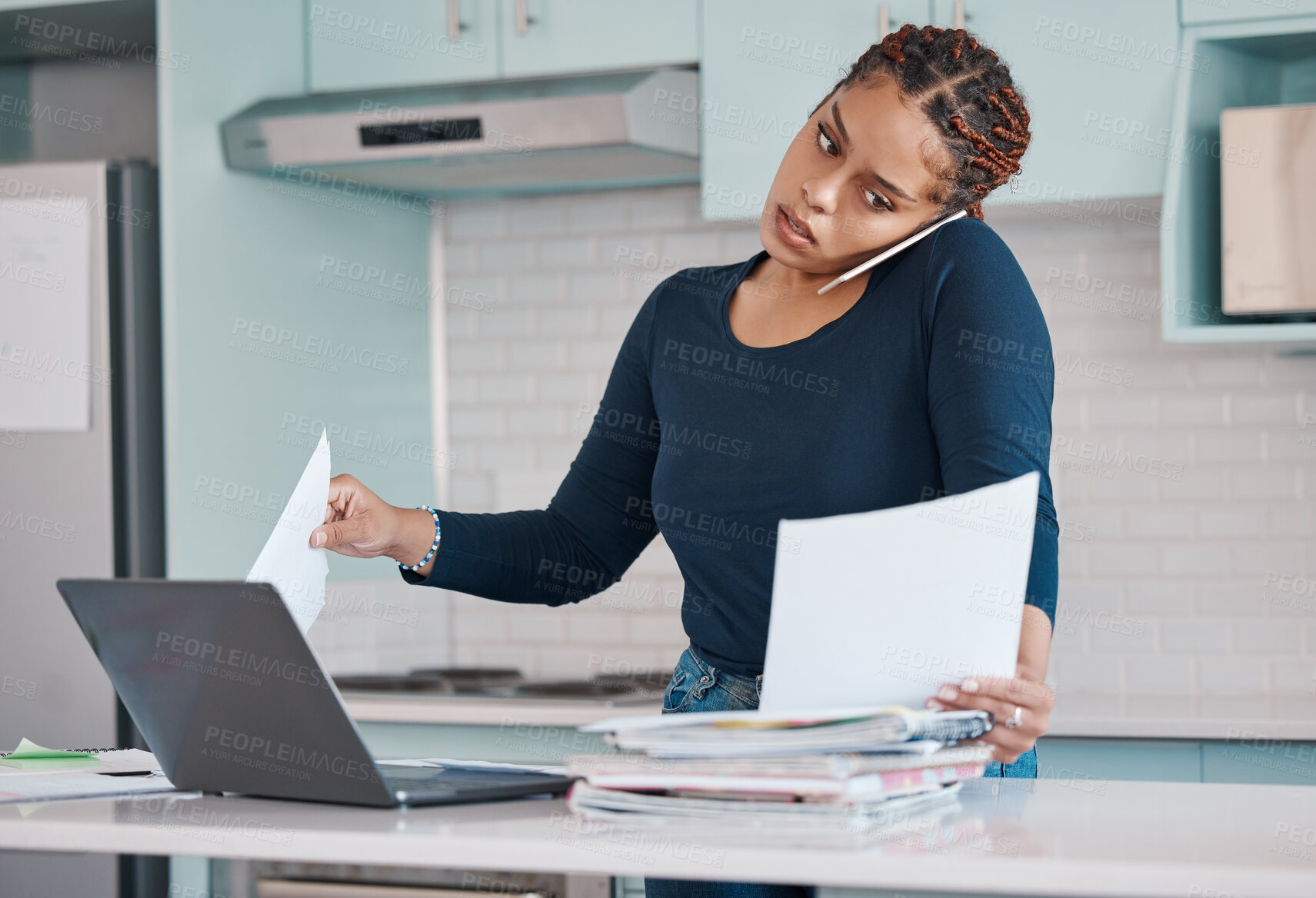 Buy stock photo Black business woman working from home in freelance, multitasking paperwork with laptop and mobile audio phone call. Internet technology in kitchen, consulting invoice documents in covid pandemic