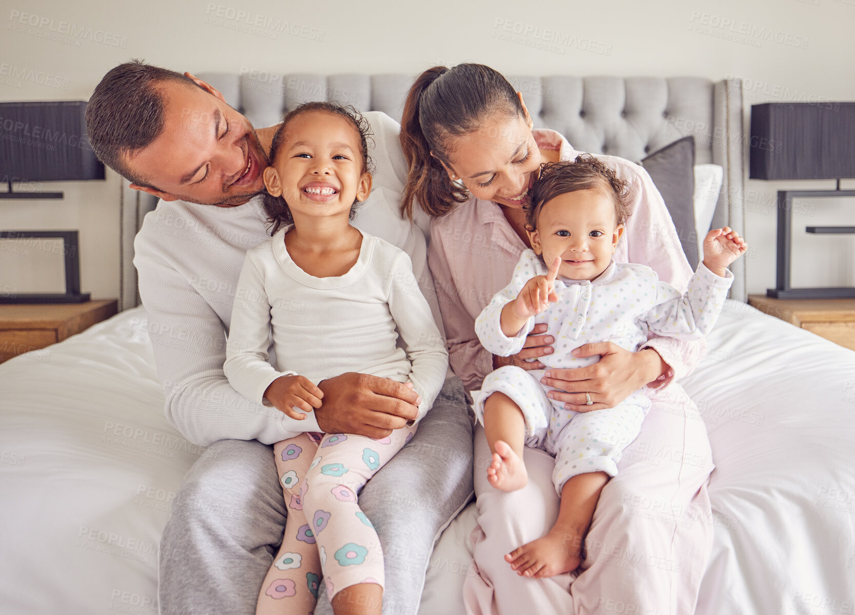 Buy stock photo Family, bonding and bed time with children and parents smile and rest together, loving and caring in bedroom. Play, sleep and routine by young man and woman enjoy the morning with happy girl in home