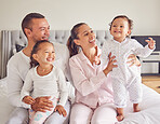 Happy family, love and morning bonding with parents, child and baby playing in the bedroom and having fun together at home. Loving and man and woman spending time with their playful kids to relax