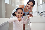 Mother with child learning to brush her teeth in a bathroom for morning dental, oral and wellness routine. Mom with girl kid with toothbrush in a portrait for dentistry, support and mouth healthcare 