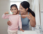 Children, dental and toothbrush with a girl and her mother brushing their teeth together in the bathroom of their home. Family, hygiene and oral with a woman and daughter practicing care and hygiene