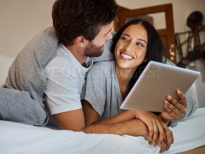 Buy stock photo Happy couple, smile and tablet in bedroom entertainment, love and care relaxing together at home. Man and woman smiling for fun bonding time streaming on wifi in bed with touchscreen technology