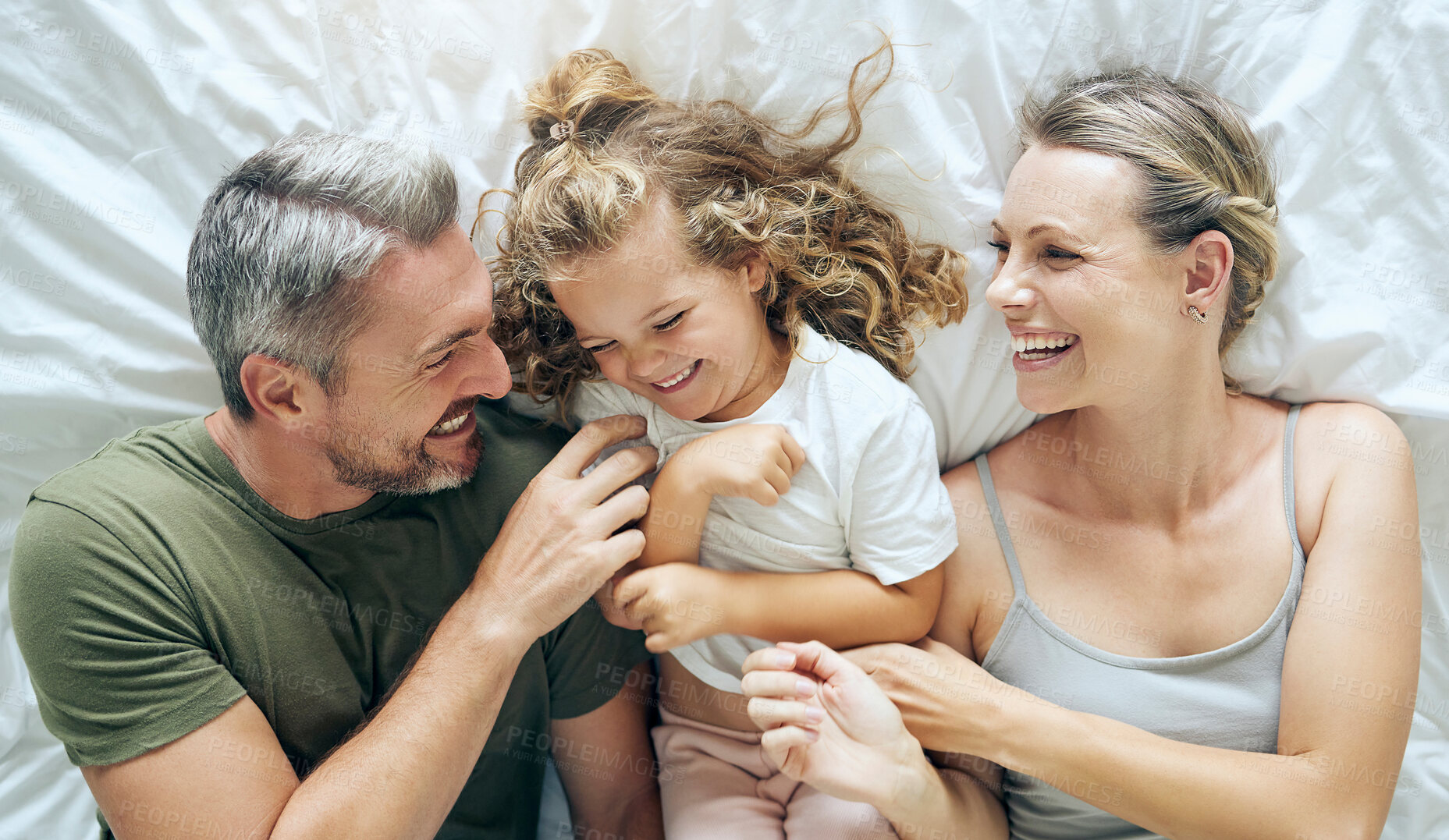 Buy stock photo Happy family, bedroom and above child smile, play or enjoy bonding together at house or home. Funny dad, mother and young girl love smiling, laughing or excited with happiness and joy in family home