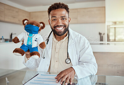 Buy stock photo Child doctor, pediatrician and healthcare work holding a teddy bear toy and looking happy and friendly while sitting in his office in a hospital. Health, care and smile of male medical physician 