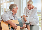 Old couple, guitar and love in home, sofa or couch playing a romantic, lovely or affection musical song for wife. Romance, retired senior man and woman play string instrument in living room or house.