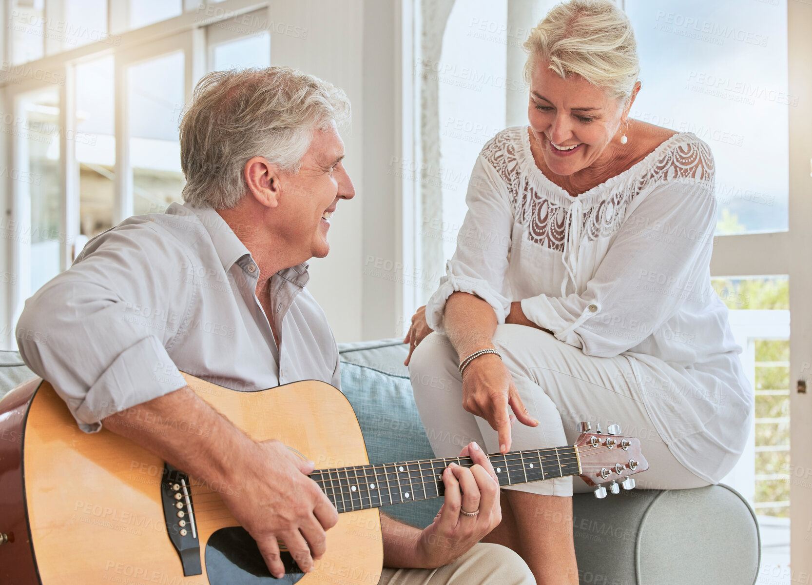 Buy stock photo Old couple, guitar and love in home, sofa or couch playing a romantic, lovely or affection musical song for wife. Romance, retired senior man and woman play acoustic string instrument in living room.