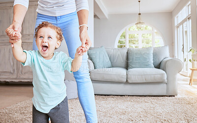 Buy stock photo Mother helping baby walk his first steps in living room for child development, growth and physical progress with lens flare. Young excited kid learning, walking with love and support from mom at home