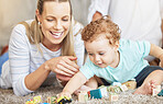 Mother, kid and play learning block toys on floor for educational bonding time together in family home. Young, caring and loving woman helping toddler with child development and coordination skills.