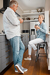 Coffee, love and couple with a senior man and woman drinking coffee together in the kitchen of their home. Retirement, smile and morning with an elderly male and female pensioner enjoying tea