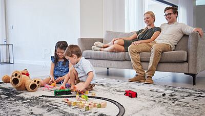 Buy stock photo Happy family, bonding and children playing in living room, relax and cheerful in their home together. Loving parents smile and enjoy parenthood, watching kids play on a floor while resting on couch