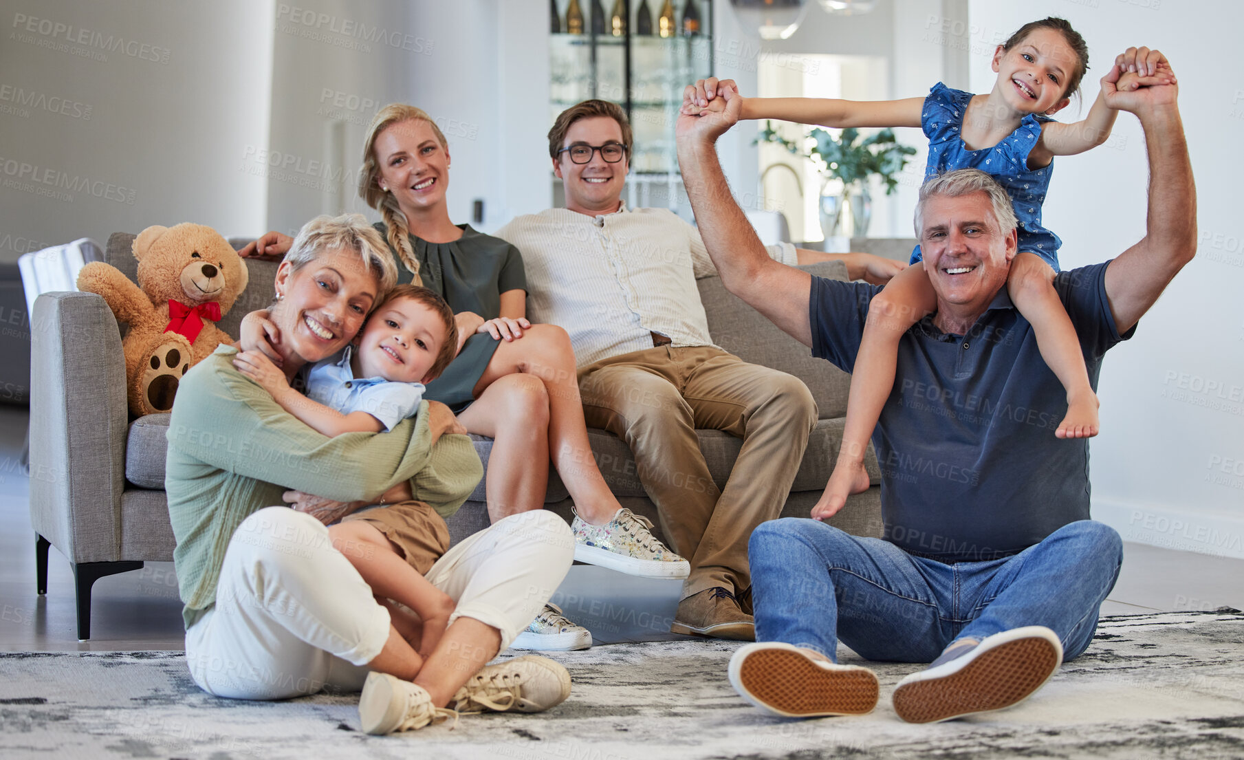 Buy stock photo Happy, family and smile for love, care and playful happiness together in the living room at home. Portrait of people in joyful generations smiling and bonding fun with children and grandparents