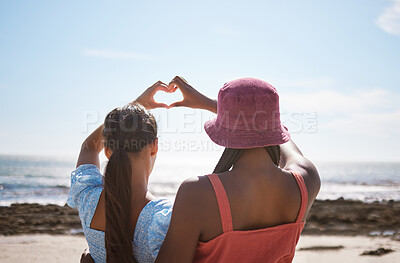 Buy stock photo Beach, heart sign and women friends with love for summer and ocean on blue sky and sunshine. Behind of lesbian couple or gen z people with care hands, icon or emoji for outdoor vitamin d or earth day