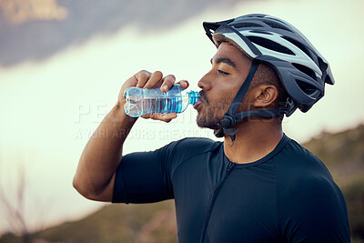 Buy stock photo Fitness man, cycling and drinking water bottle and wearing safety helmet outdoors in nature during summer. Male athlete, exercise and hydration riding a bike to practice, workout or train for sports