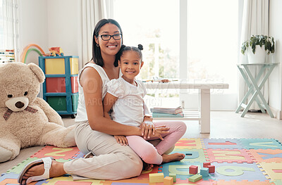 Buy stock photo Portrait of a happy mother and child in a playroom playing with education building blocks. Happiness, care and smile of woman holding and sitting with her girl kid in colorful room with toys at home.