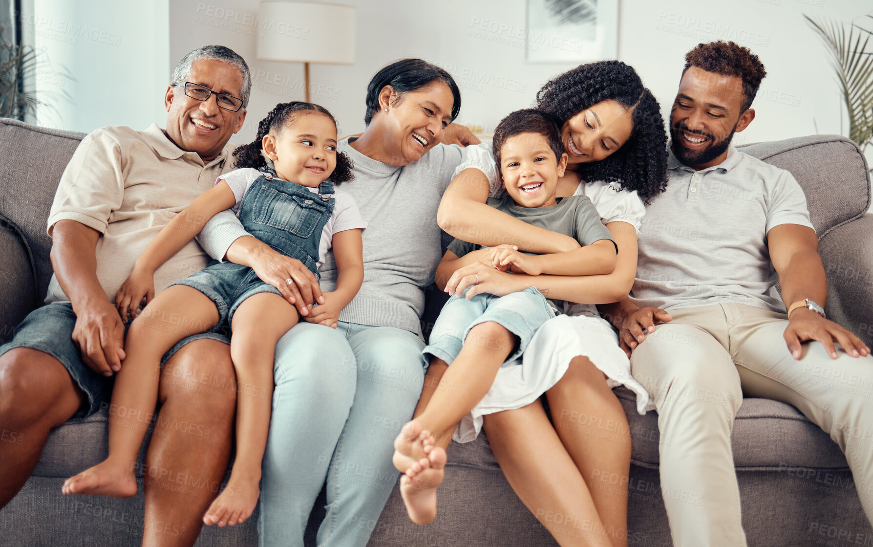 Buy stock photo Love, children with grandparents in a big family as mother and father hugging kids on the sofa or couch. Dad mom and young children happy to enjoy bonding with lovely grandmother and old man at home