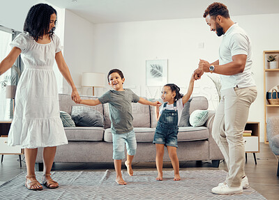 Buy stock photo Happy family, dancing and having fun while sharing love, energy and bond while holding hands in the living room at home. Man, woman and sibling kids playing and laughing enjoying active time together