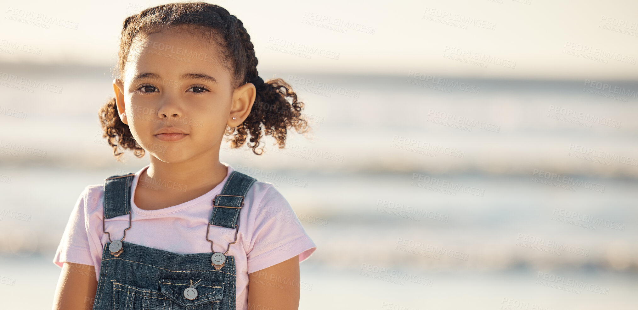 Buy stock photo Portrait of girl child on holiday, at beach and standing in the sun by the ocean. Kid on summer holiday, travel to the coast in the sunshine and sand. Toddler by sea, childhood memory and on vacation