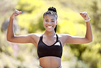 Sports woman with strong biceps doing exercise and training. Portrait of young black woman showing strength, fitness and muscles after exercising outside in nature. Motivation and workout for female