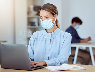 Buy stock photo Laptop, face mask and corporate employee working on a project while sitting at a desk in the office. Professional woman typing company documents on her computer during a global covid pandemic.