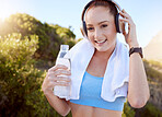 Music, fitness and water with a sports woman listening to audio on headphones during her workout, exercise or training outside. Motivation, health and wellness with a young female athlete outdoor