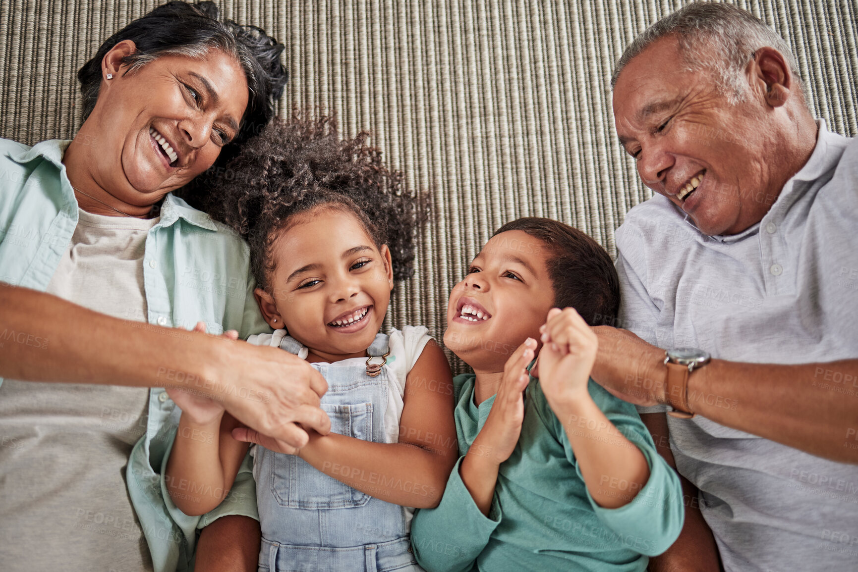 Buy stock photo Happy family, grandparents and children on a sofa, relax and laughing while bonding in e living room together. Love, laugh and happy kids playing, enjoy time and fun game with elderly man and woman