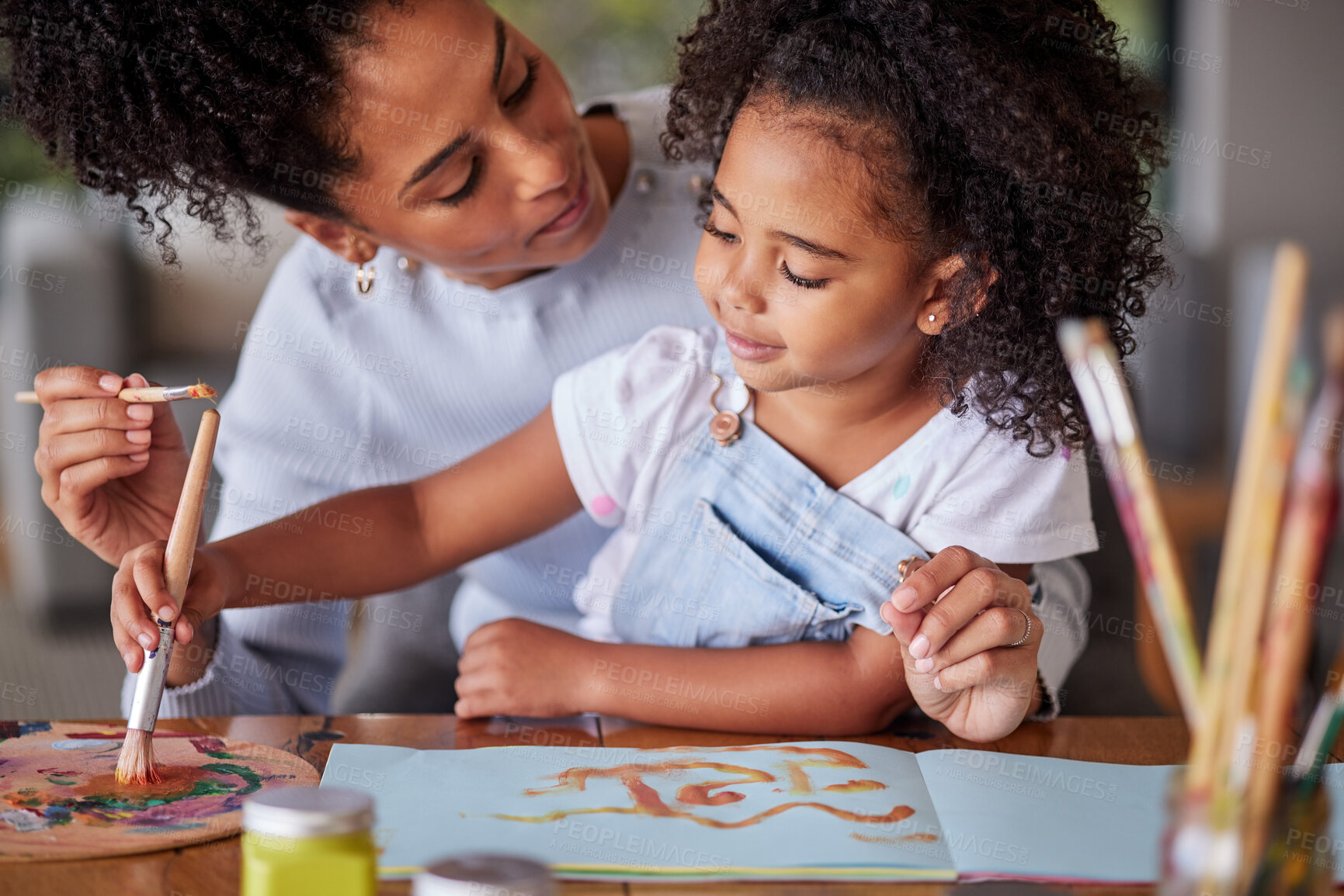 Buy stock photo Mother and girl painting with watercolor paint and brush using a paintbrush on paper. Latin girl and mom using paintbrush drawing color art for a school project for fun, creativity and hobby together