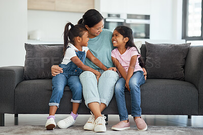 Buy stock photo Family, love and single mother with kids looking happy, relax and smiling sitting together and bonding on sofa in lounge at home. Asian babysitter woman hugging cute girls, daughters or twin sisters