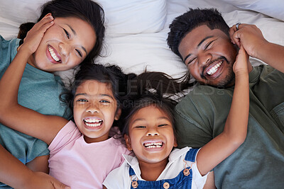 Buy stock photo Happy, smile and portrait of family from above in bed bonding together in a bedroom at home. Happiness, love and interracial parents lying with girl children in holiday house room while on vacation.