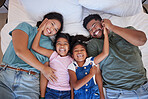 Happy family, love and morning smile with parents and children lying and playing in bed for fun together at home from above. Laugh, man and woman bonding with playful kids relax in bedroom with love