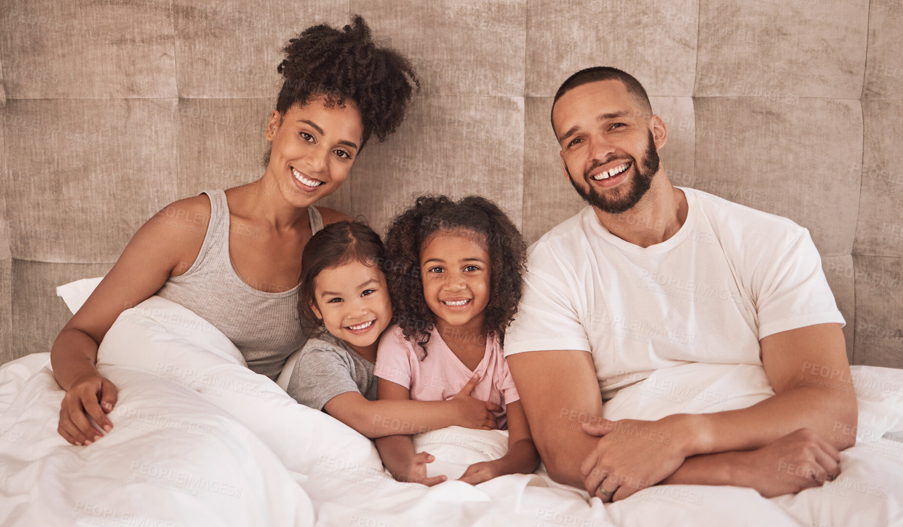 Buy stock photo Portrait of happy latino family bonding on a bed while carefree, relax and rest in a bedroom together. Young loving parents enjoy free time with their children or daughter with affection together 