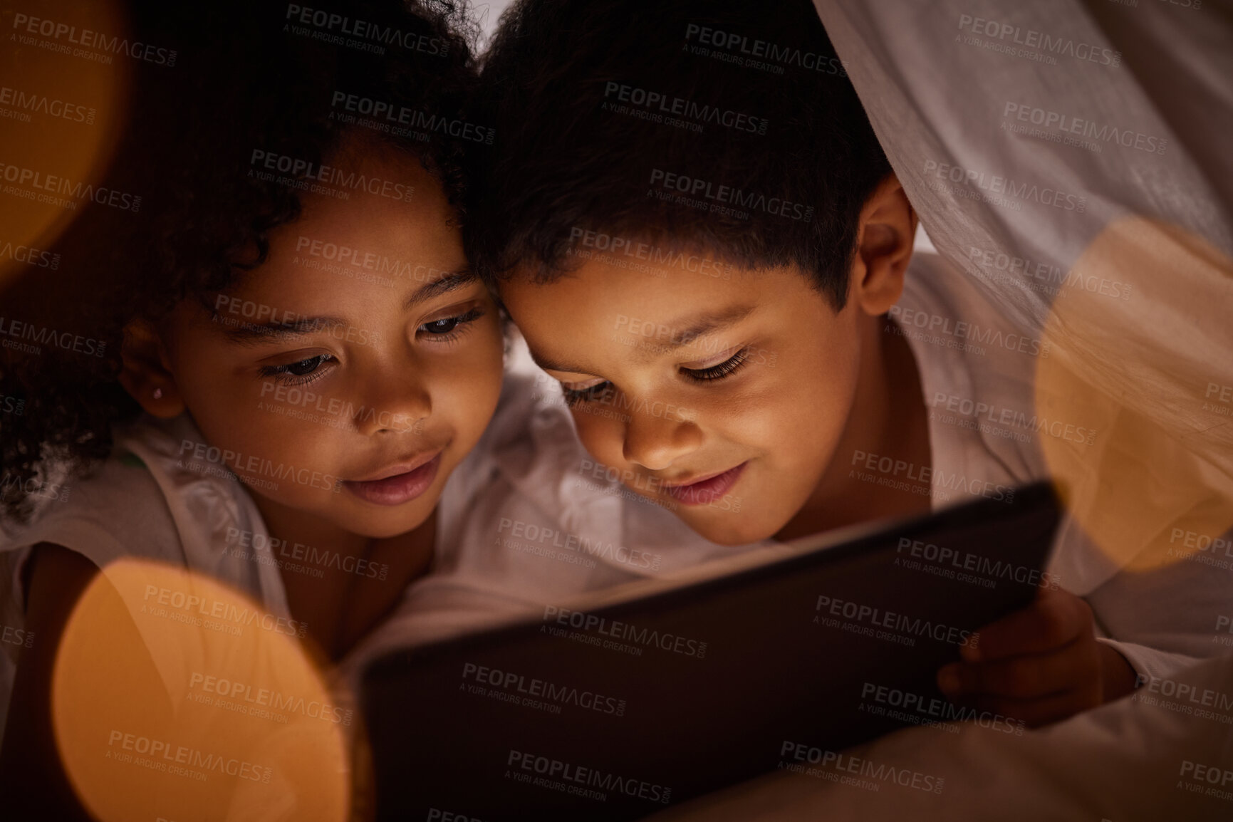 Buy stock photo Children, digital tablet and streaming movies on internet in fun blanket fort at home at night. Happy, boy and girl kids playing and enjoying online games together with subscription on mobile device.