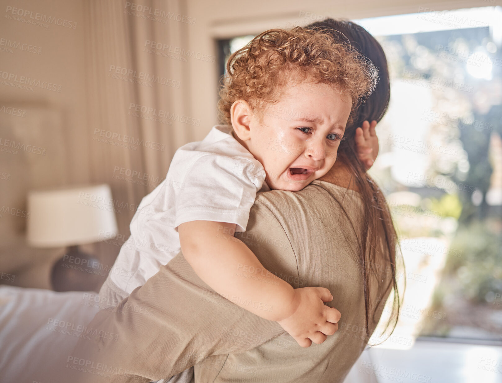 Buy stock photo Crying, sad and tears of baby with mom for comfort, safety and attention while hungry, upset or tired in a family home. Toddler boy child cry while in arms of caring woman babysitter, mother or nanny