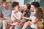 Love, relax and happy family bonding on a sofa, laughing and playing in a living room together. Parents, kids and grandmother talking and enjoying quality time indoors with sweet interracial children