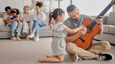 Buy stock photo Father, child and guitar teaching, learning or music in the living room with family in the background. Girl and man play with a musical instrument together bonding in the house with creative hobby