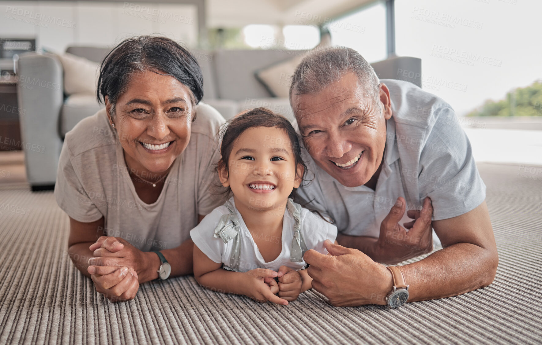Buy stock photo Relax, happy and grandparents with girl in living room with family from Indonesia for lifestyle, love and retirement. Care, smile and portrait of elderly man and old woman with child at home together