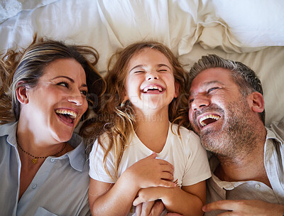 Buy stock photo Mother, father and child happy in bed together in the morning, laughing at joke and bonding in house. Family with love in home bedroom, being funny and smile for comedy while relax with girl