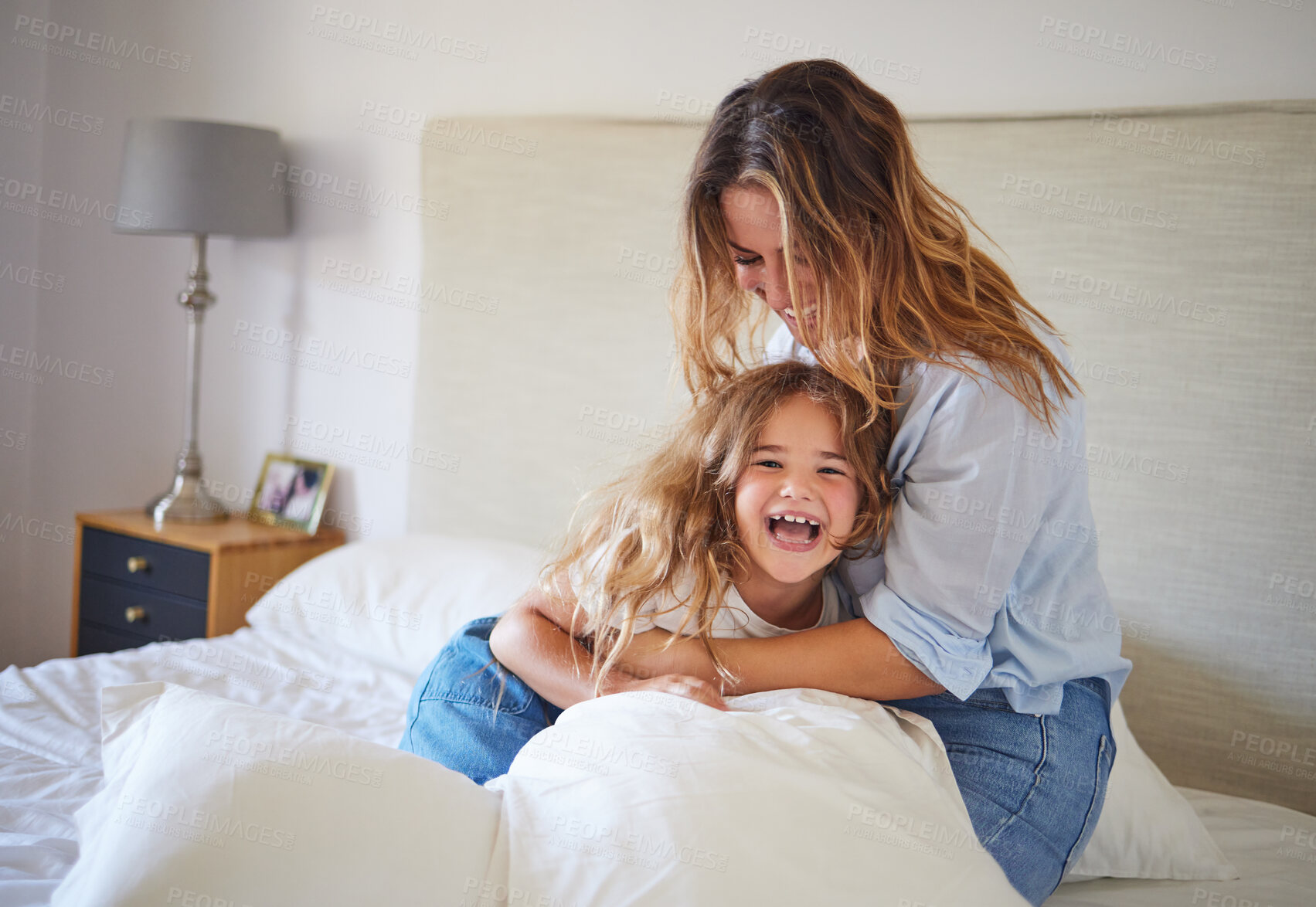 Buy stock photo Mom and child on the bed playing together, having fun and laughing. Portrait of mother and daughter in bedroom, smiling while woman tickle young girl. Family, love and laughter in morning at home