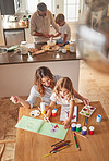 Family, mother and girl painting from above, learning and education in the home. Development, growth and kids, parents and baking in kitchen with father, bonding and care, support and love in house.