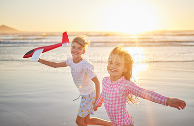 Buy stock photo Children running with airplane toys on beach together for wellness, exercise and healthy development on sunset horizon and ocean waves. Kids having fun and playing for outdoor summer holiday portrait