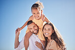 Parents, child and happy with sky in background for portrait of family together outside. Mom, dad and girl on shoulders, love and happiness outdoors with blue sky backdrop while on holiday or travel