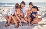 Family, ocean and kids with parents on blanket in sand on summer holiday. Mom, dad and children relax at beach picnic in Mexico. Freedom, fun and vacation, happy man and woman with girls at the sea.