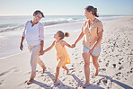 Family smile at beach, mom and grandmother hold hands with girl child on holiday. Children love vacation by the sea, happy grandma in retirement and walking in sand together as they relax as a group 