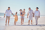 Family, love and beach with a girl, grandparents and parents walking on the sand with a view of the sea or ocean and horizon. Love, travel and summer with a man, woman and daughter happy on vacation