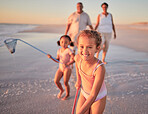 Children, fishing and family with a girl at the beach with her grandparents and sister for summer holiday. Kids, happy and ocean with a child on sand by the sea with her grandmother and grandfather