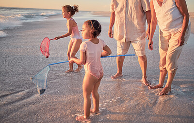 Buy stock photo Learning, beach and children fishing in the ocean with parents, bonding and having fun with fishing net in nature. Kids, teaching and happy family bonding in sea water with girl playing enjoy summer